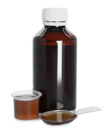 Bottle of cough syrup, dosing spoon and measuring cup on white background