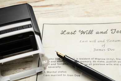 Photo of Last Will and Testament, stamp and pen on white wooden table, closeup