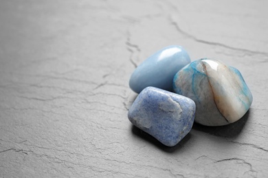 Photo of Blue gemstones on grey table, space for text