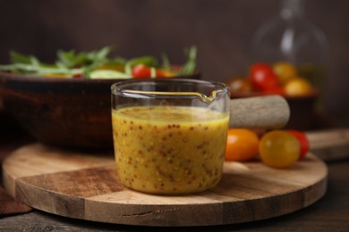 Photo of Tasty vinegar based sauce (Vinaigrette) on wooden table, closeup