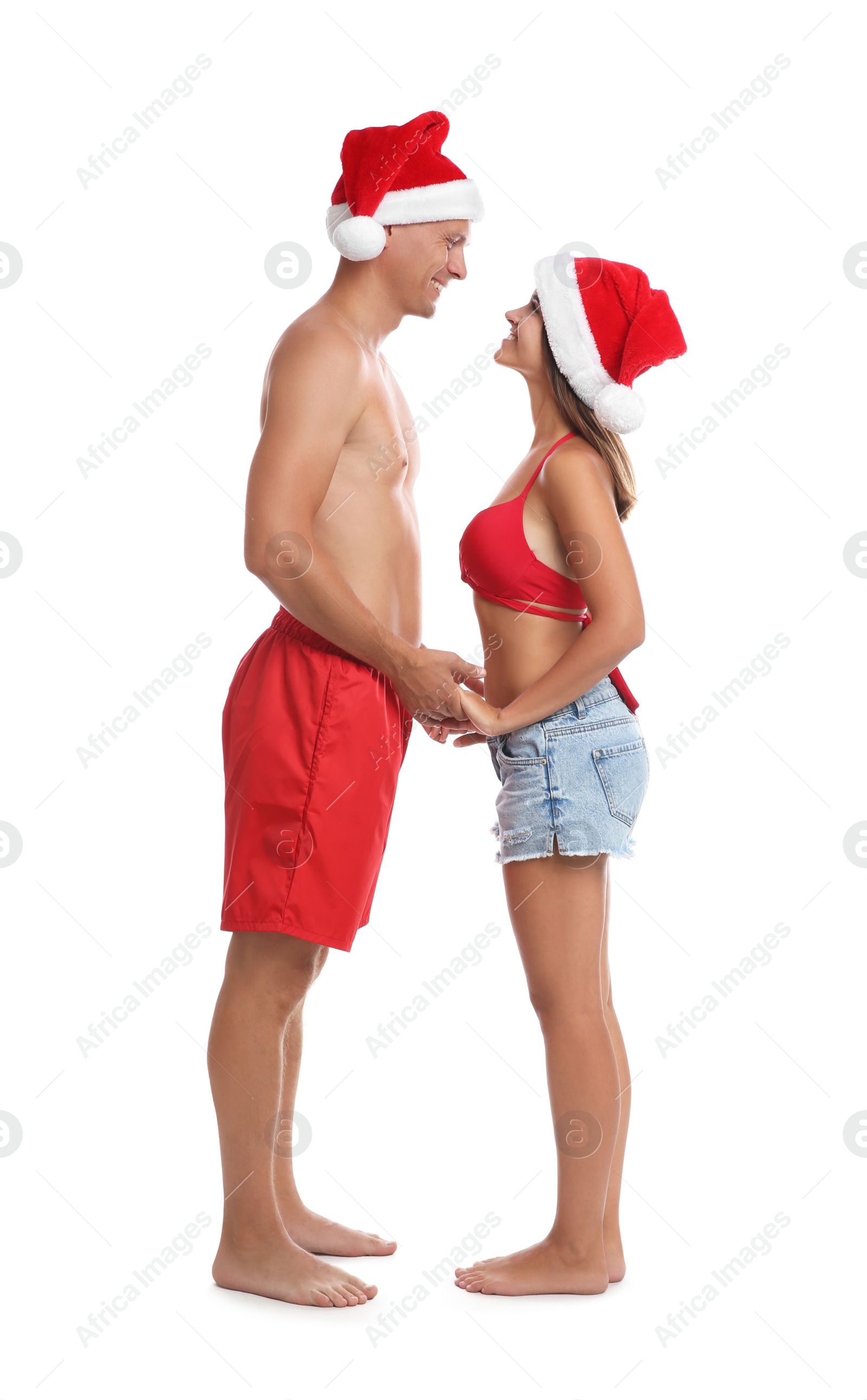 Photo of Happy couple with Santa hats together on white background. Christmas vacation