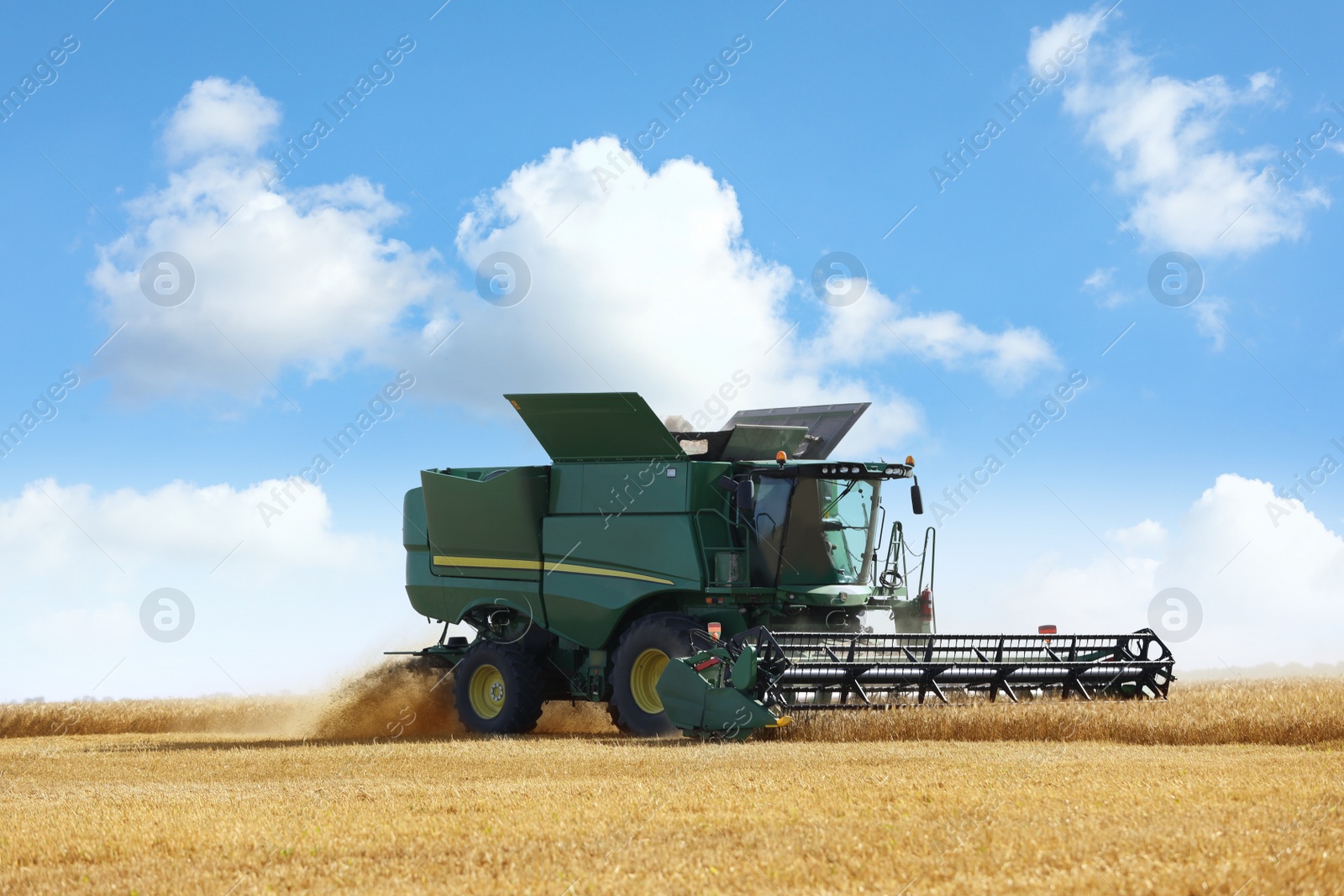 Photo of Modern combine harvester working in agricultural field