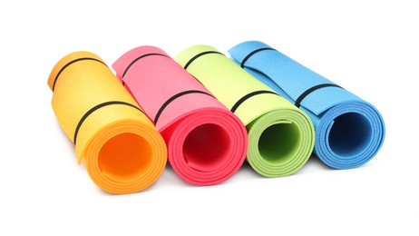 Photo of Colorful rolled camping or exercise mats on white background