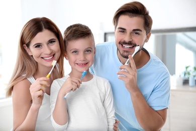 Photo of Portrait of happy family with toothbrushes in bathroom. Personal hygiene