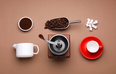 Flat lay composition with vintage manual coffee grinder on brown background