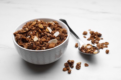 Photo of Bowl of tasty granola with nuts and dry fruits on white marble table