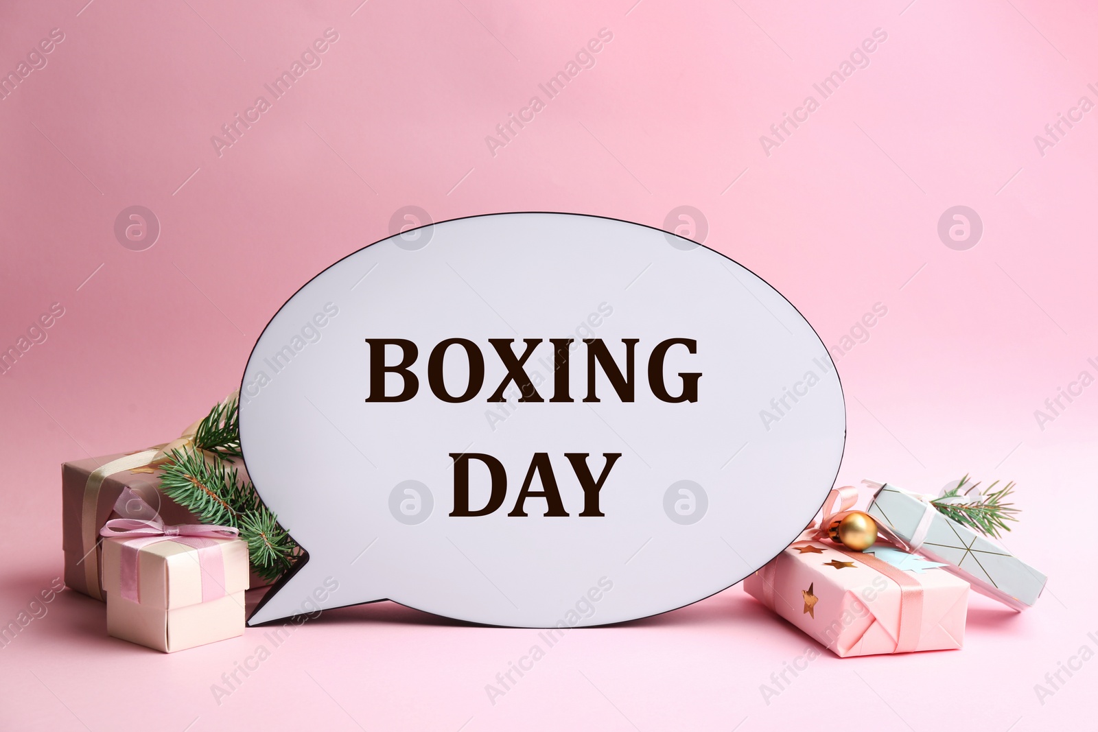 Photo of Speech bubble with phrase BOXING DAY and Christmas decorations on light pink background