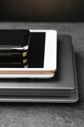 Stack of electronic devices on grey table, closeup