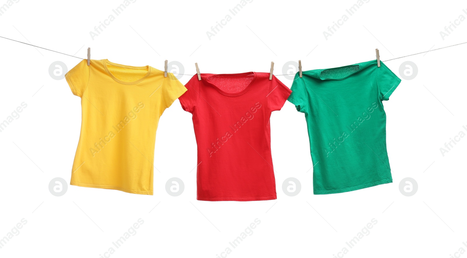 Photo of Different bright t-shirts drying on washing line against white background