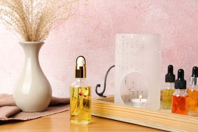 Photo of Aroma lamp and essential oils on wooden table