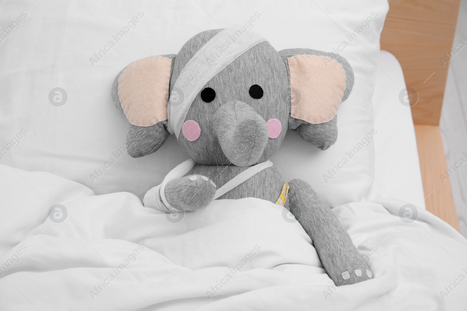 Photo of Toy elephant with bandages lying in bed