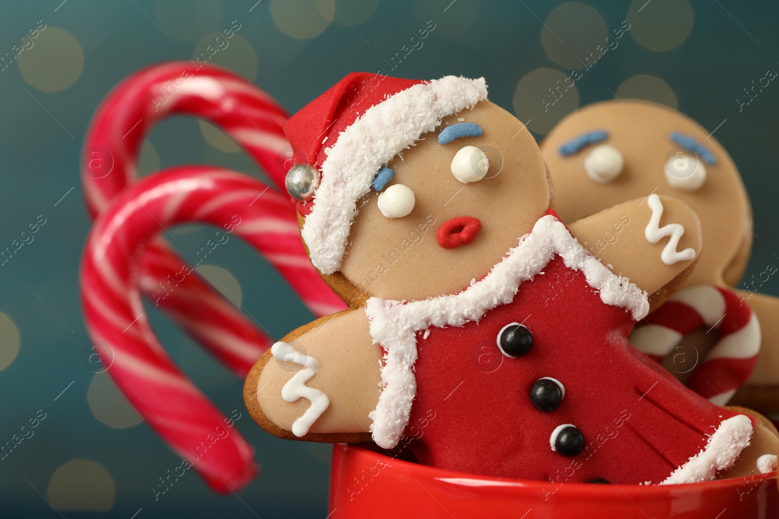 Photo of Delicious homemade Christmas cookies in cup against blurred festive lights, closeup