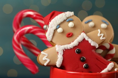 Photo of Delicious homemade Christmas cookies in cup against blurred festive lights, closeup