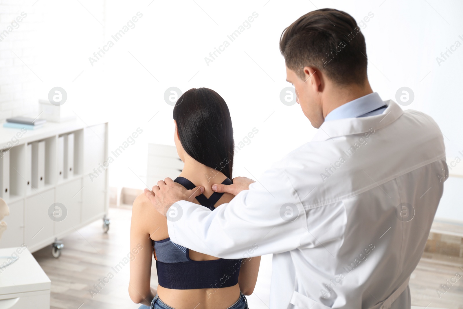 Photo of Professional orthopedist examining woman in medical office