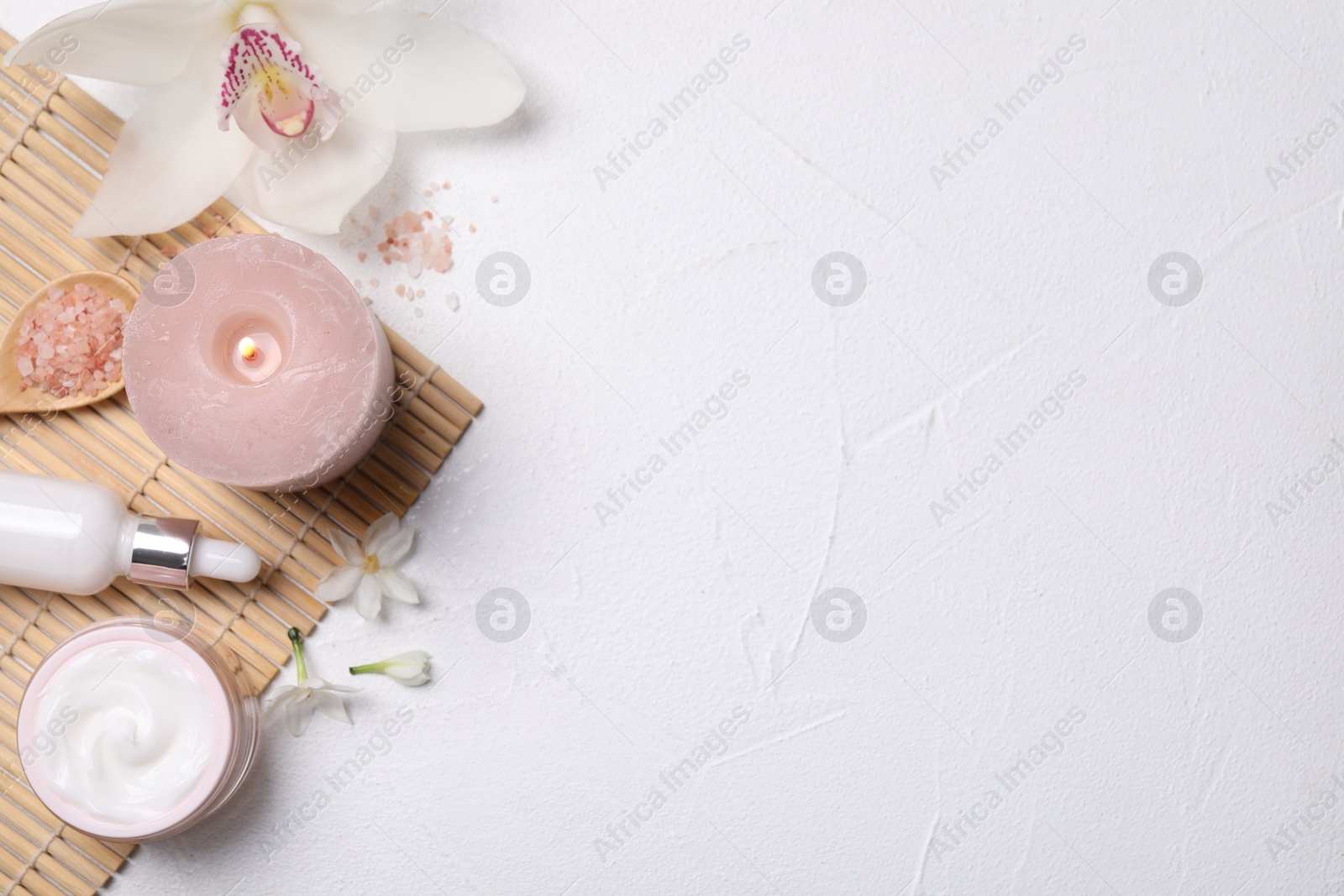 Photo of Beautiful spa composition with cosmetic products and flowers on white table, flat lay. Space for text