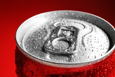 Photo of Wet closed can on red background, closeup