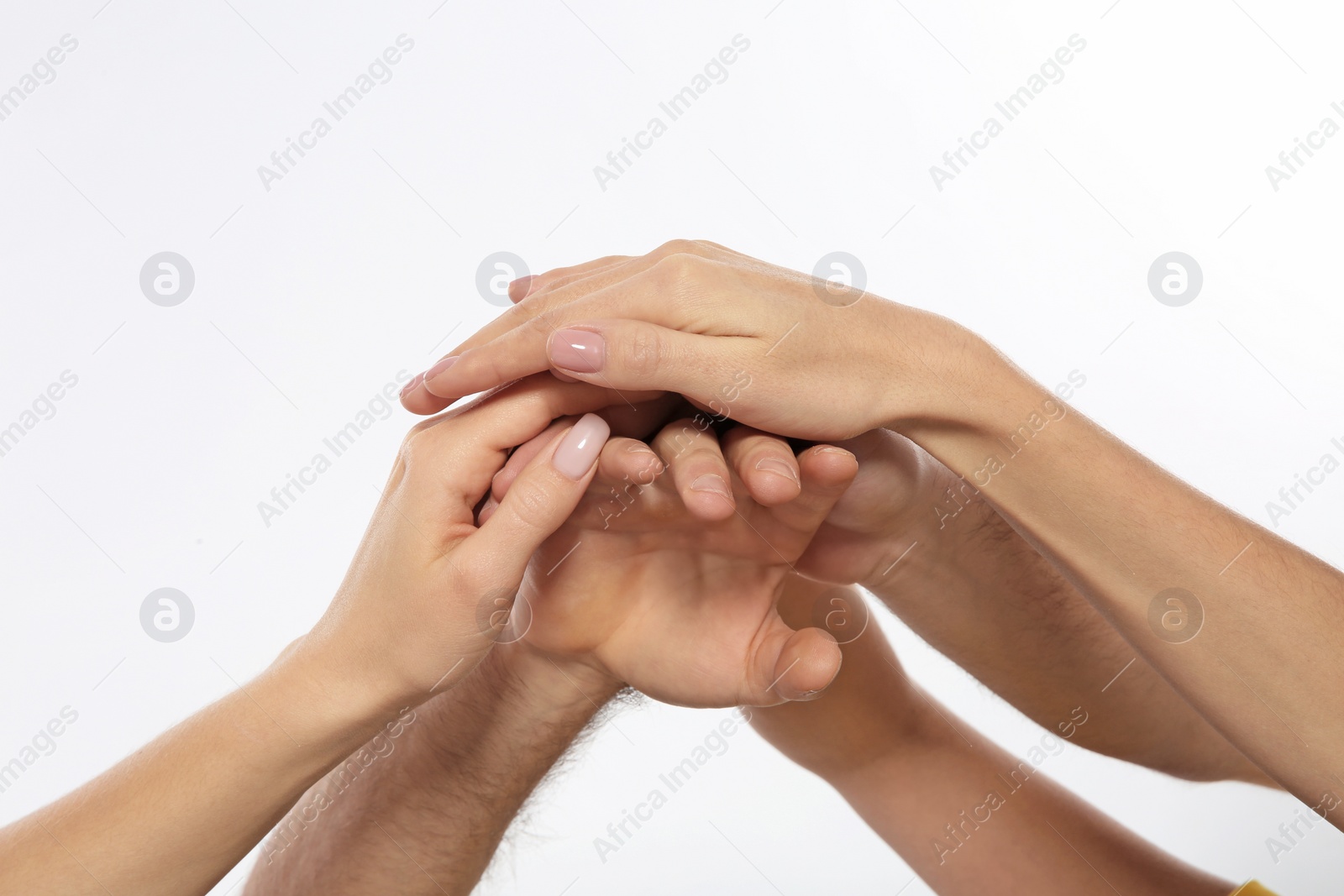 Photo of Young people holding hands together on white background, closeup. Team victory concept