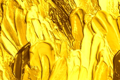 Image of Strokes of shiny golden paint as background, closeup