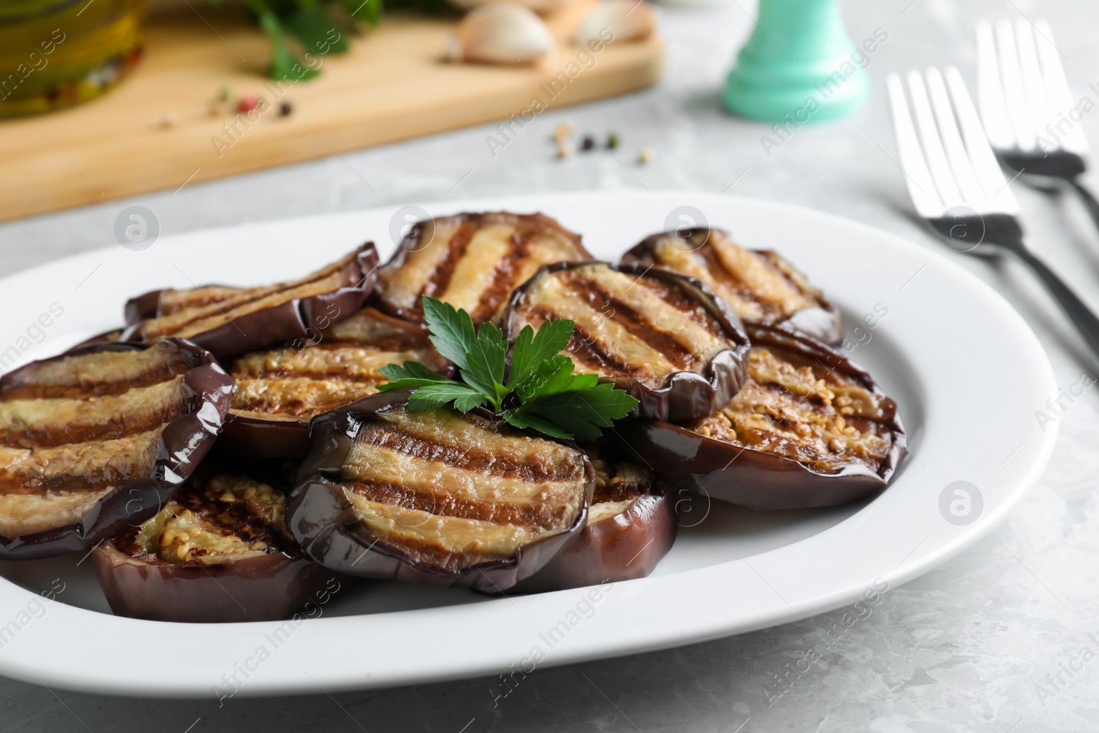 Photo of Delicious grilled eggplant slices served on grey table, closeup