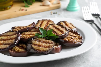 Photo of Delicious grilled eggplant slices served on grey table, closeup