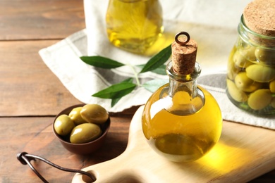 Composition with fresh olive oil on table