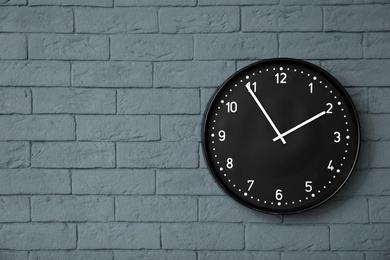 Modern clock on brick wall. Time concept