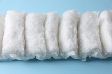 Photo of Soft clean cotton on light blue background, closeup