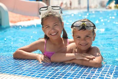 Photo of Little children wearing diving mask in swimming pool. Summer vacation