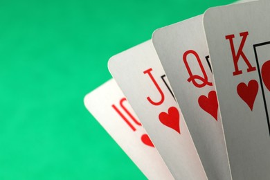Photo of Hand of playing cards on green background, closeup. Space for text