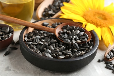 Photo of Bowl and spoon with sunflower seeds on table