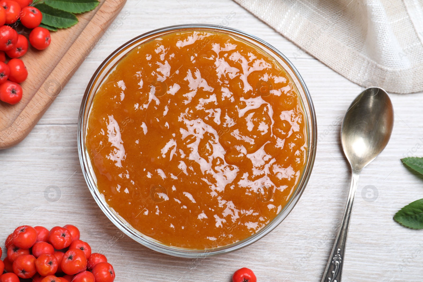 Photo of Flat lay composition with delicious rowan jam on white wooden table