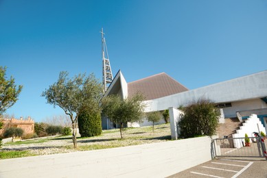 Photo of Modern church with green lawn on sunny day