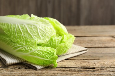 Photo of Fresh ripe Chinese cabbage on wooden table, closeup. Space for text