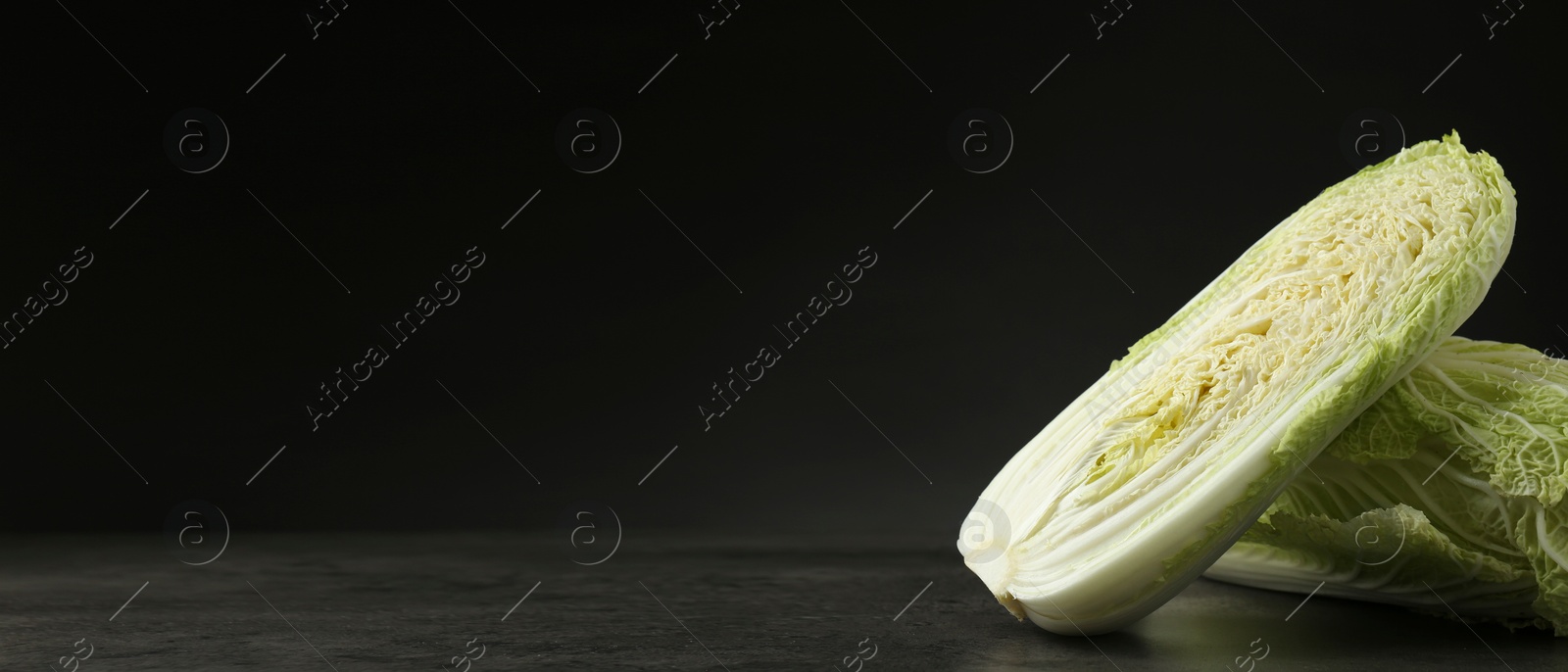 Image of Fresh ripe Chinese cabbages on grey table against black background, space for text. Banner design