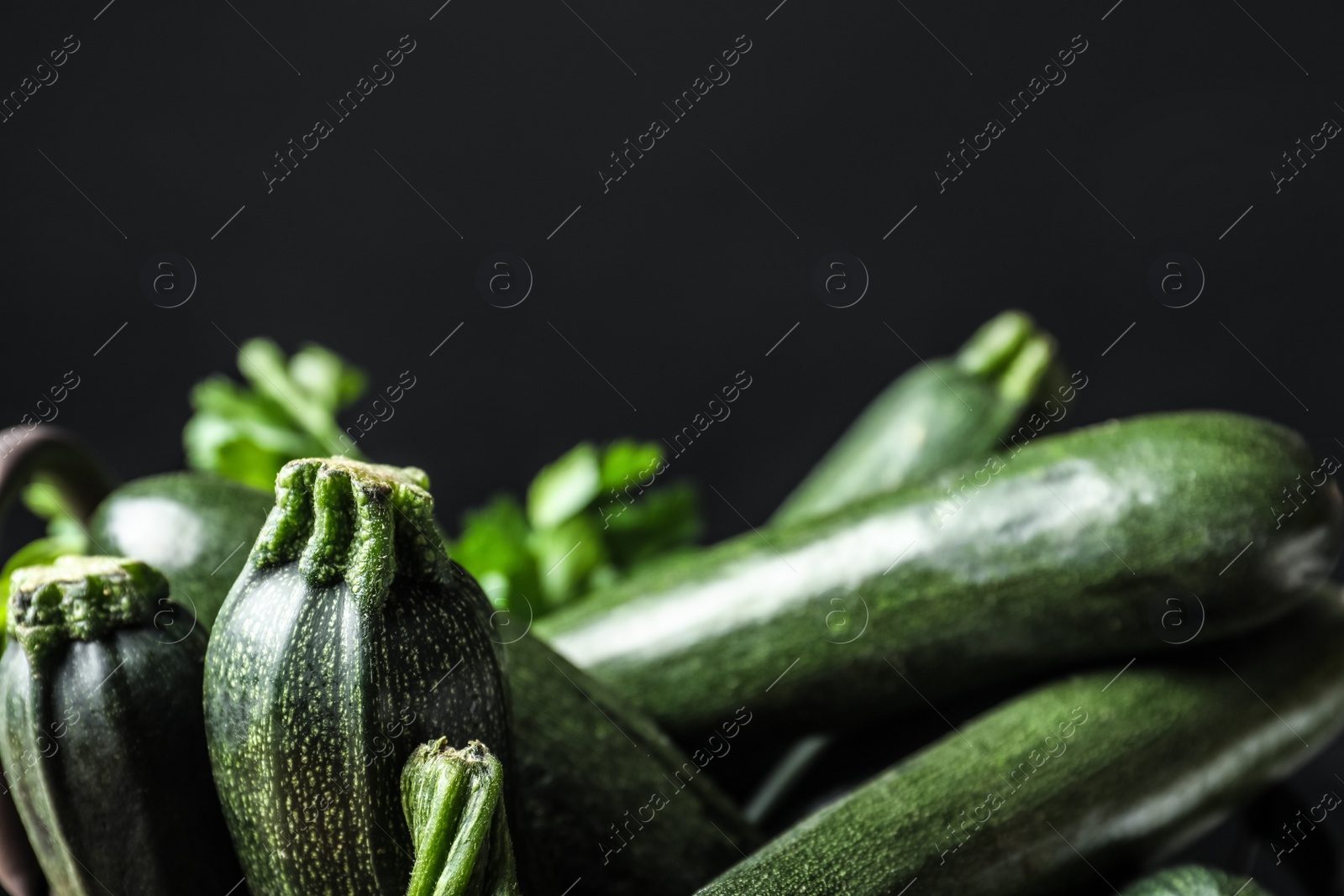 Photo of Raw green zucchinis on black background, closeup