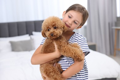 Photo of Little child with cute puppy in bedroom. Lovely pet
