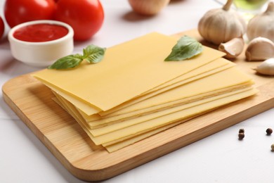 Photo of Ingredients for lasagna on white tiled table, closeup