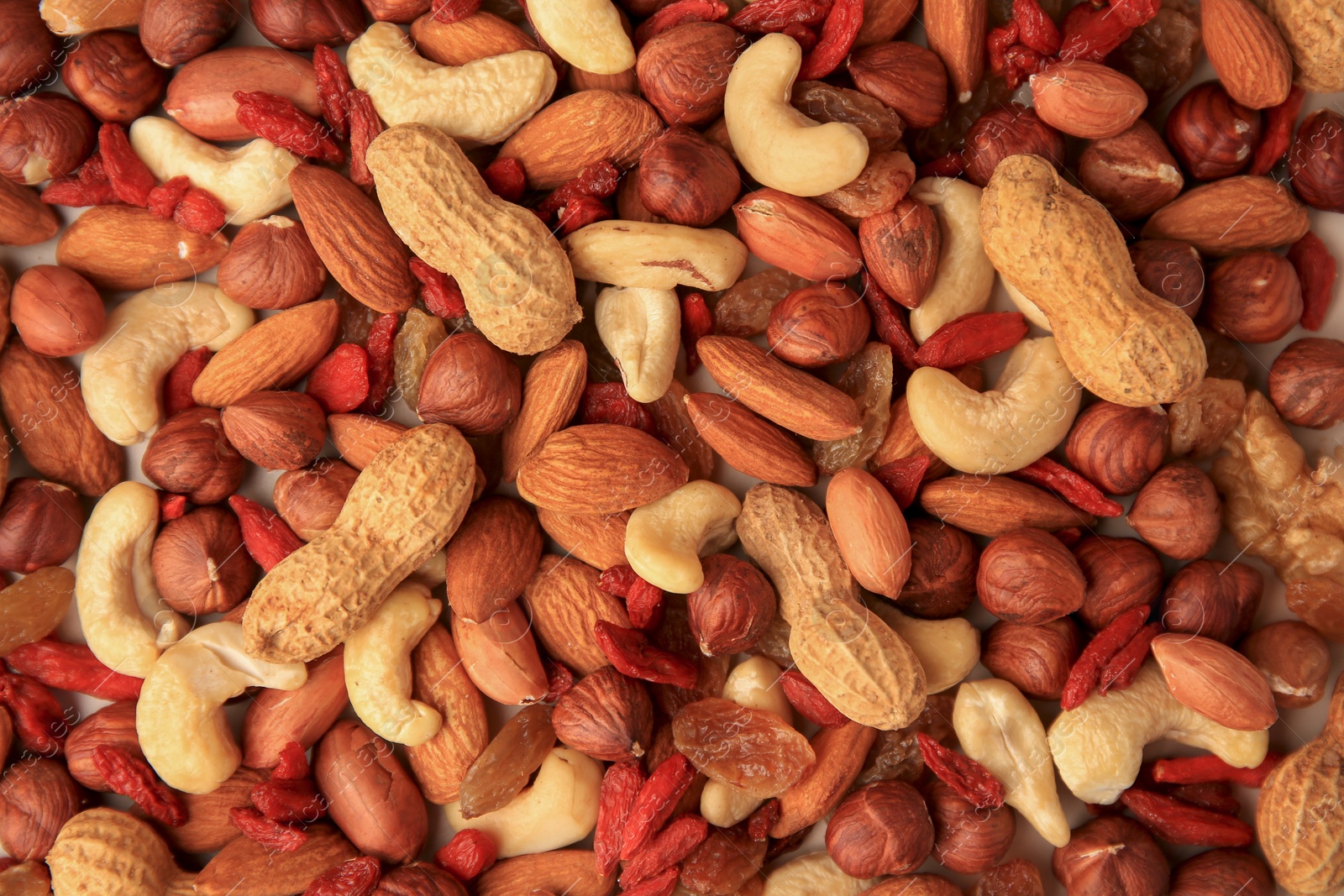 Photo of Different tasty nuts and dried fruits as background, top view