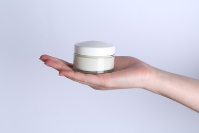 Woman with jar of cream on white background, closeup