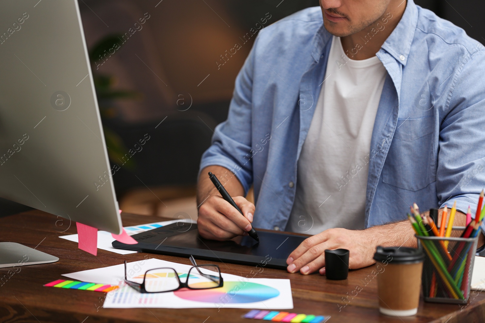 Photo of Male designer working at desk in office, closeup