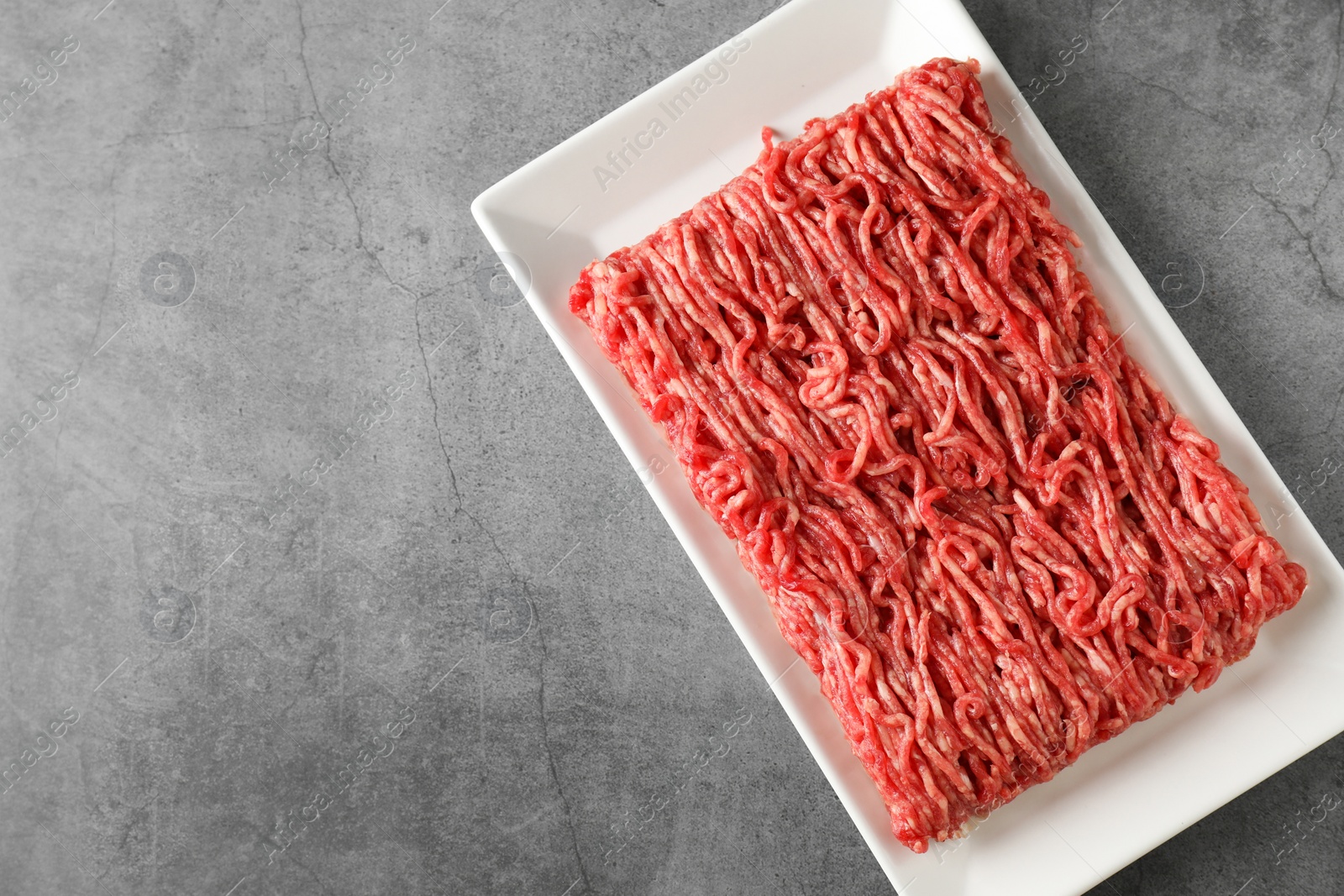 Photo of Raw ground meat on grey table, top view. Space for text