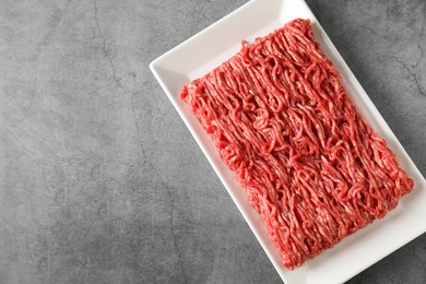 Photo of Raw ground meat on grey table, top view. Space for text