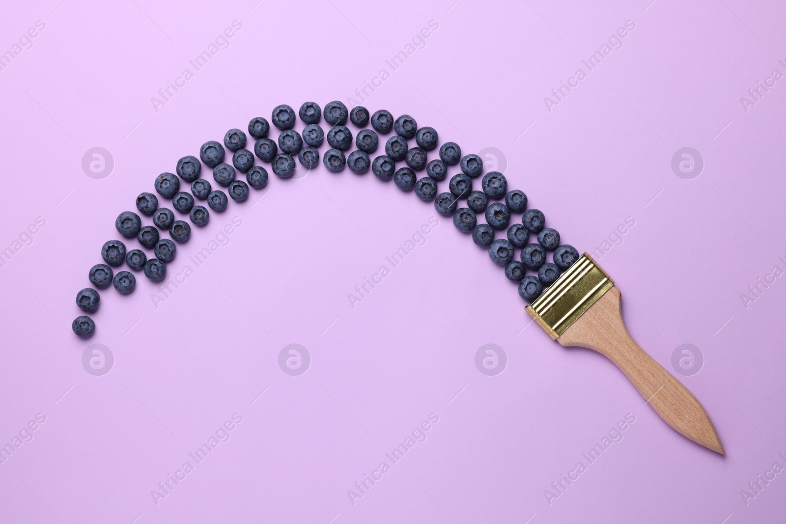 Photo of Creative flat lay composition with paint brush and blueberries on violet background