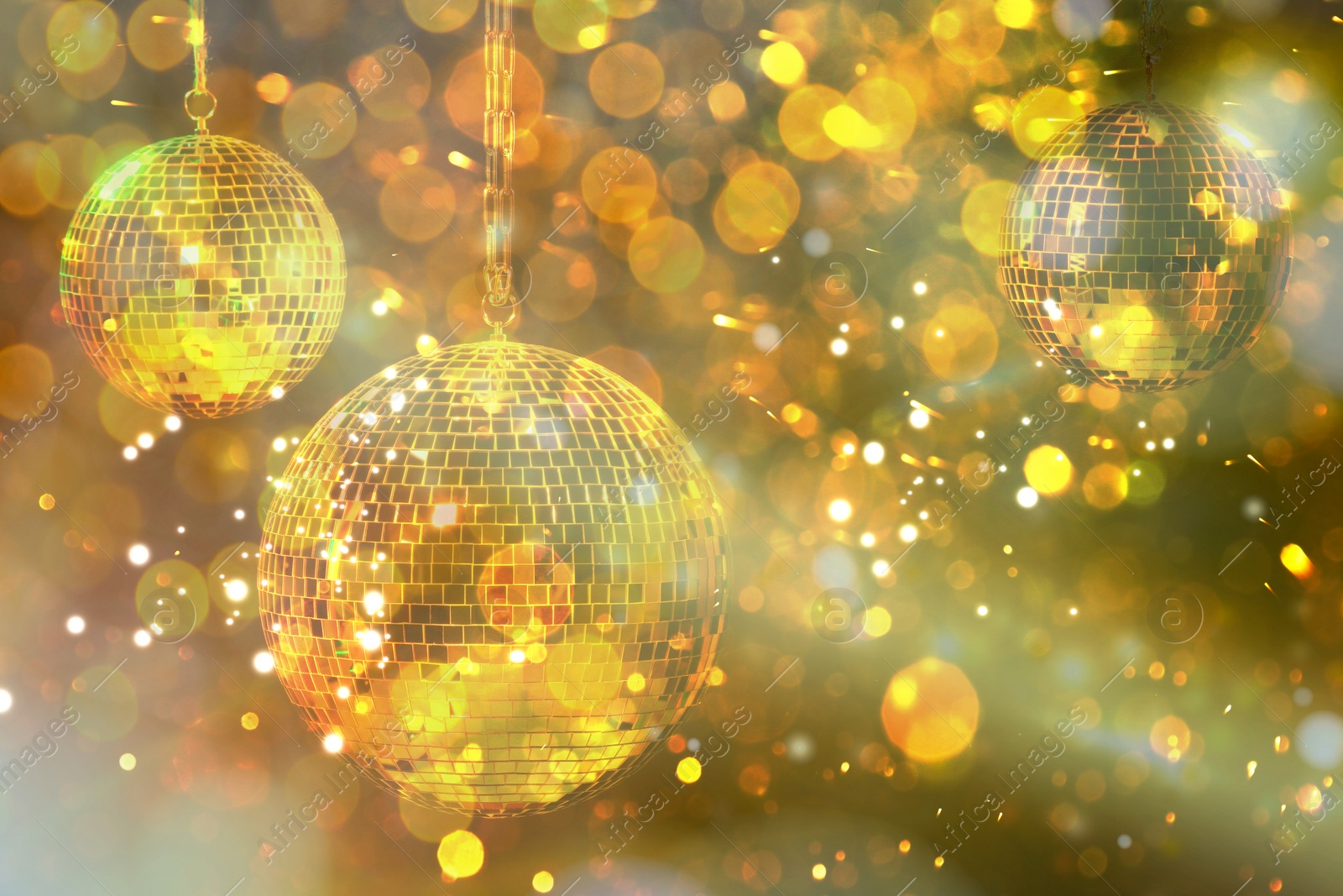 Image of Shiny bright disco balls under golden lights, bokeh effect