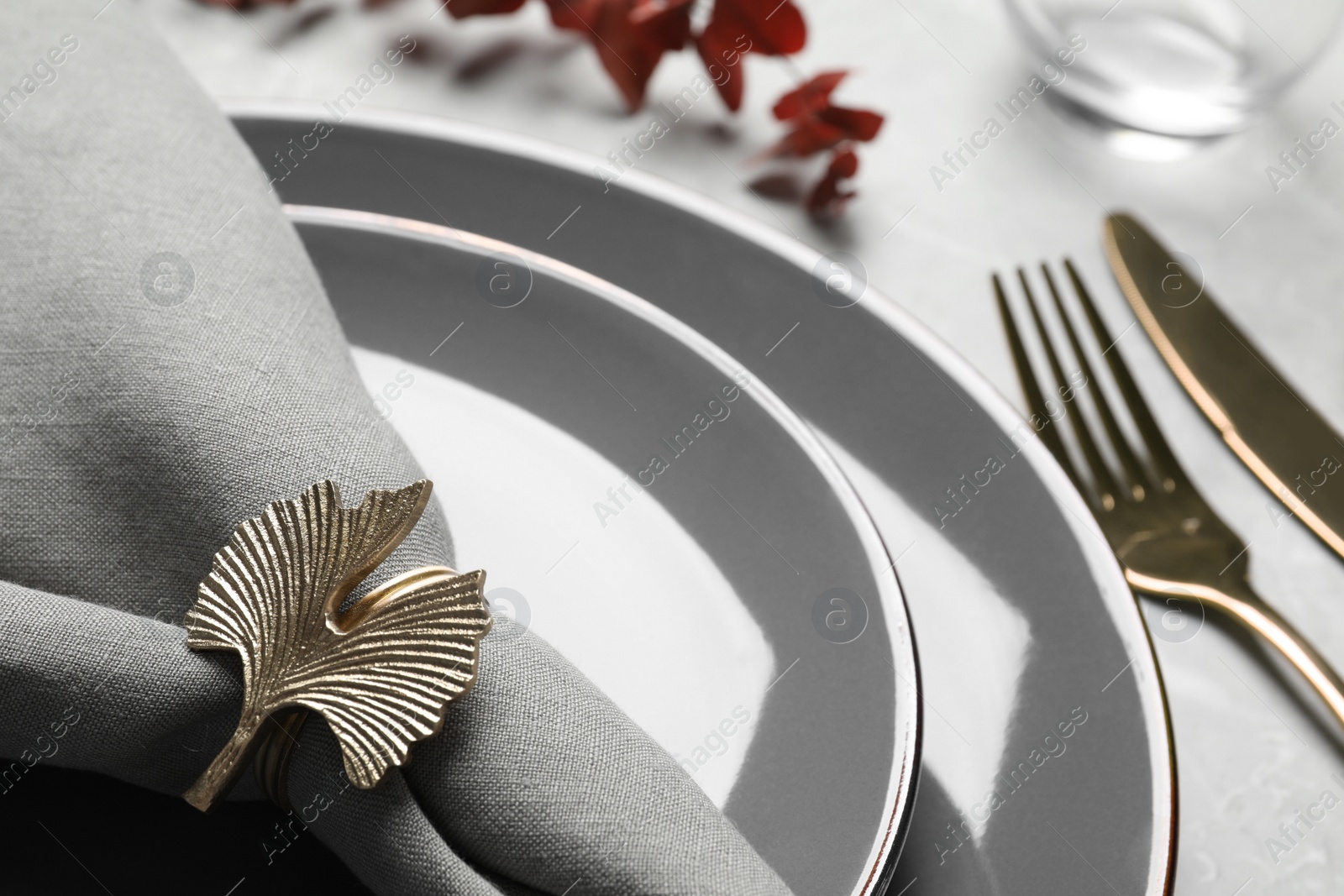 Photo of Fabric napkin and decorative ring for table setting on gray plate, closeup