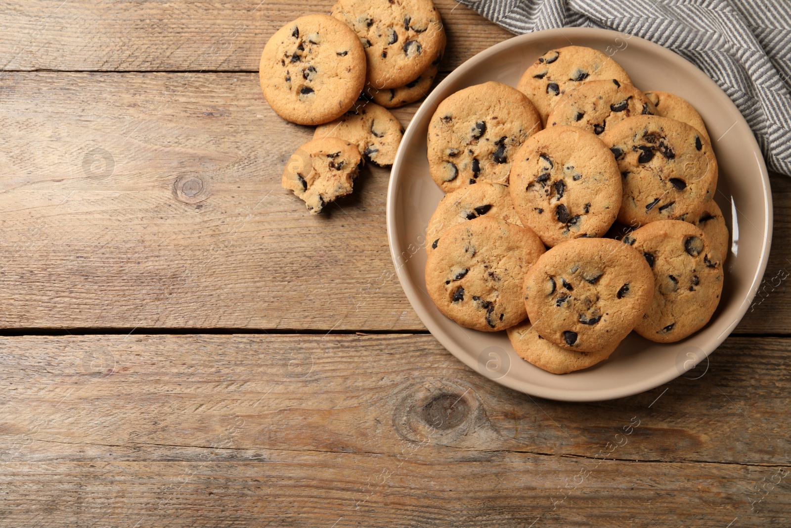 Photo of Delicious chocolate chip cookies on wooden table, flat lay. Space for text