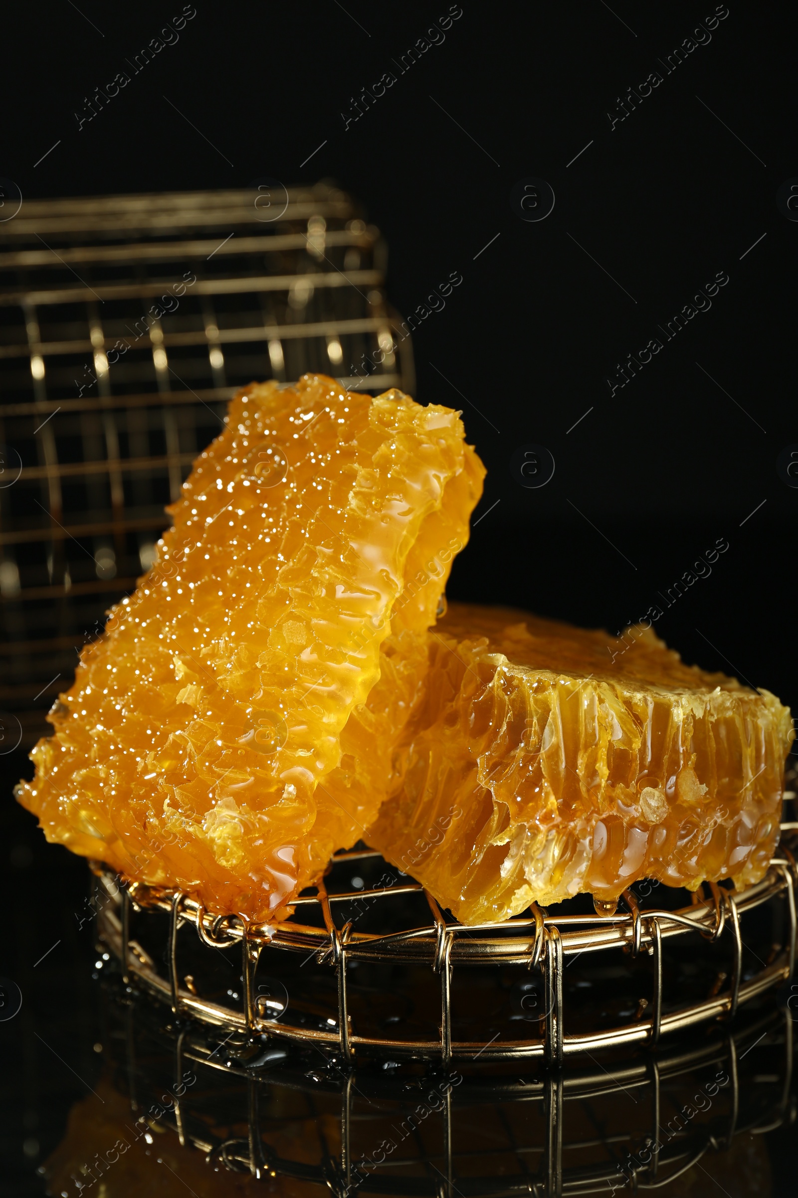 Photo of Natural honeycombs with tasty honey on black background