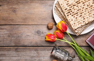 Photo of Flat lay composition with symbolic Pesach (Passover Seder) items on wooden table, space for text