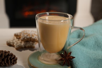 Tasty eggnog and anise star on white wooden table