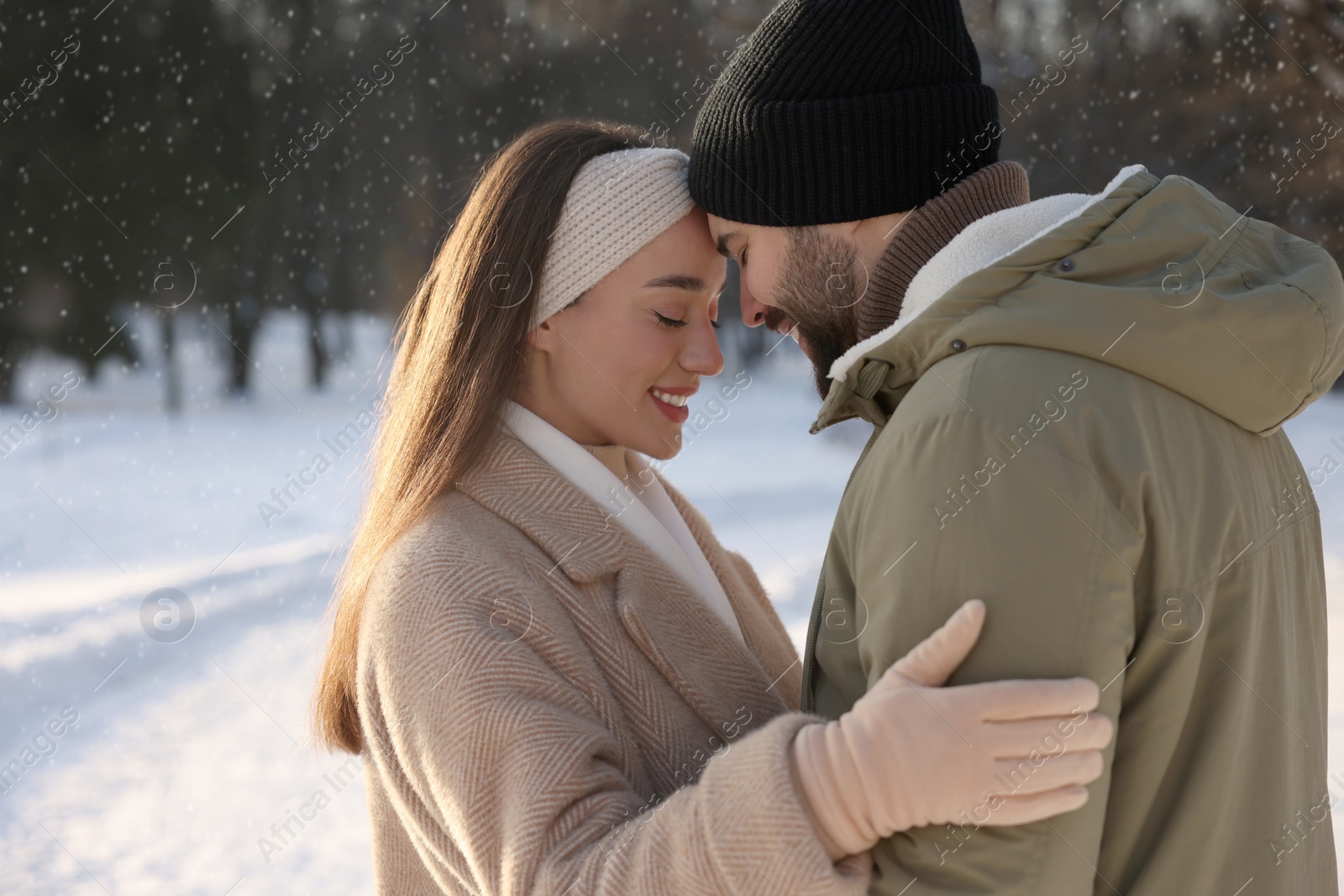 Photo of Beautiful happy couple in snowy park on winter day